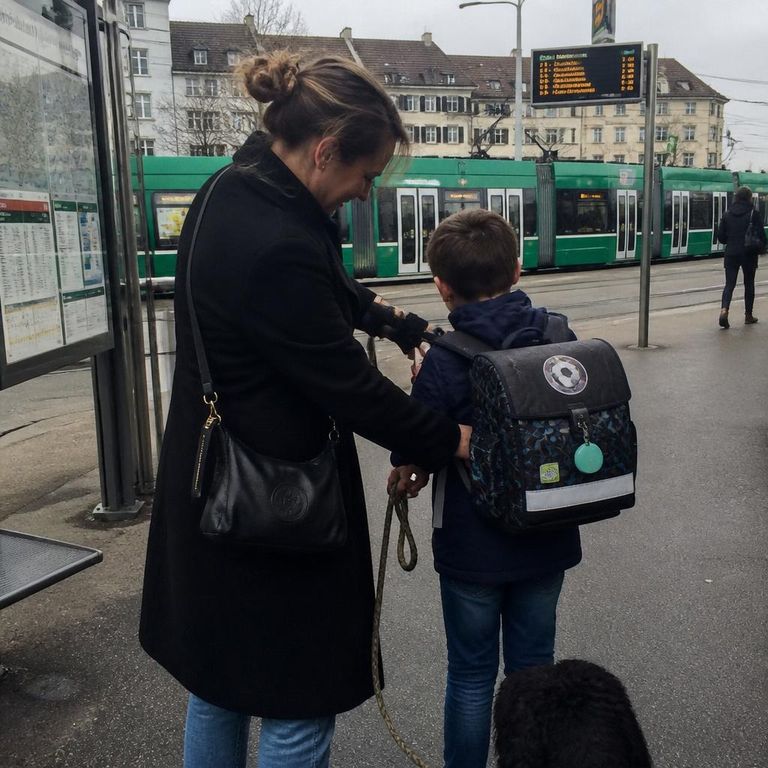 Betreuungsperson begleitet Kind mit Hund auf dem Schulweg