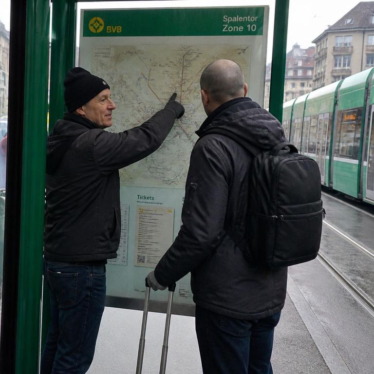 Begleitung erklärt einem Neuankömmling das Tramnetz von Basel